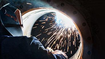 person welding a large pipe