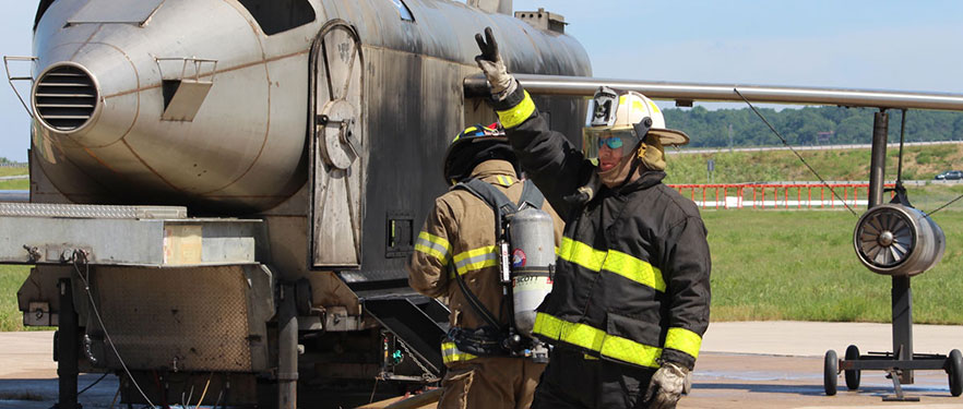 fire fighting standing next to aircraft