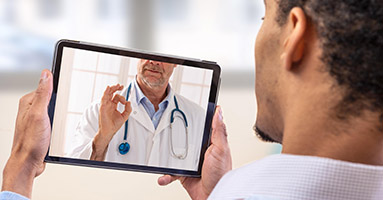 Man using tablet for virtual medical appointment
