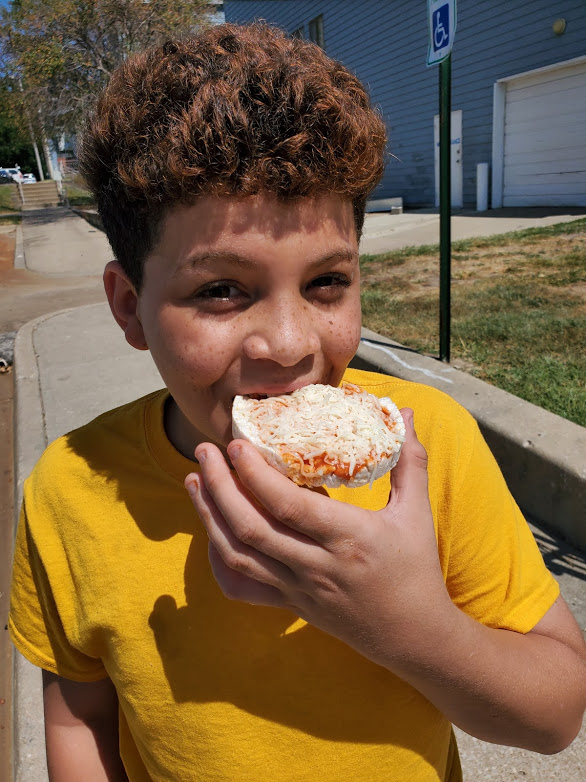Open Taii’Vionne P., a member of the Healthy Habits 4-H SNAC club in Jackson County, eats a healthy pizza snack made with a rice cake.