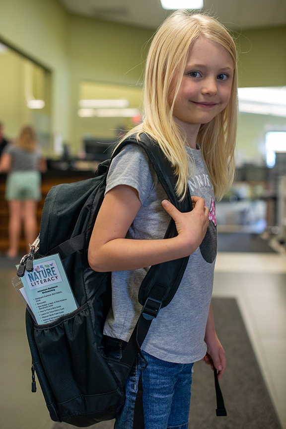 Grace Harris, a young patron of the Republic branch of the Springfield-Greene County Library District, wears an Adventure Backpack. The nature-themed backpacks were introduced this summer thanks to a collaboration of two participants in MU Extension’s Nei