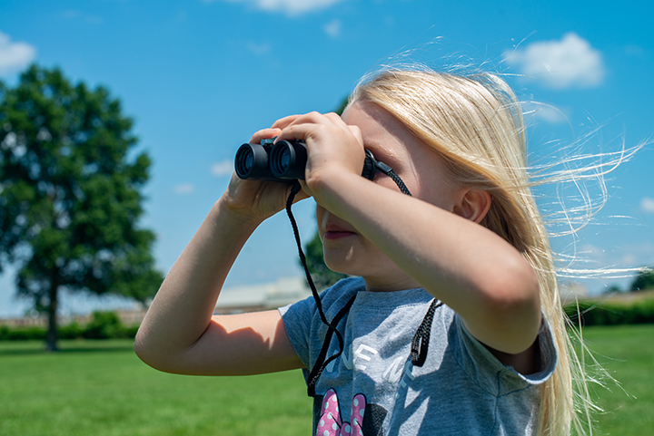 Grace Harris tries a pair of binoculars from an Adventure Backpack checked out from the Republic branch of the Springfield-Greene County Library District.