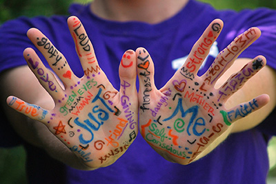 A piar of hands with self-descriptive words written on the palms.