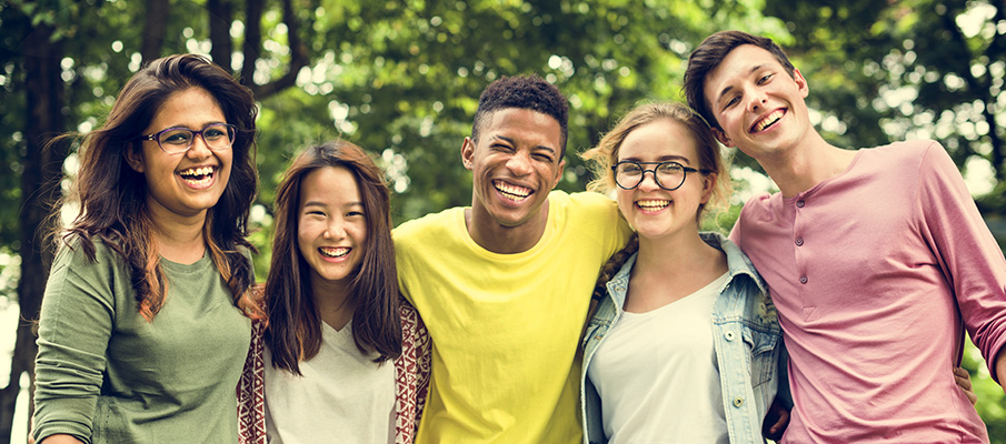 Young teens smiling and posing for a group photo.