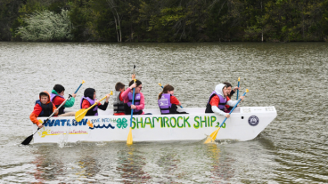 group of youth in a boat on a lake