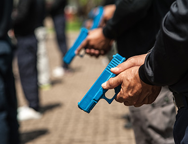 People holding law enforcement training guns