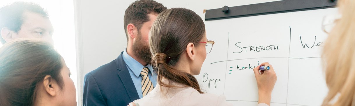 Business colleagues creating list on dry erase board