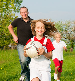 Dad and children playing soccer