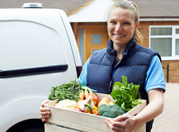 Woman delivering a box of vegetables.