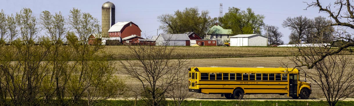 School bus passing farm