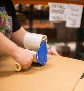 Worker taping a box closed. Image property of Court Street Custom Fulfillment. Used with permission.