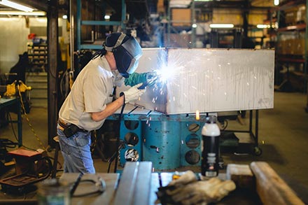 A man fabricating a medical cart.