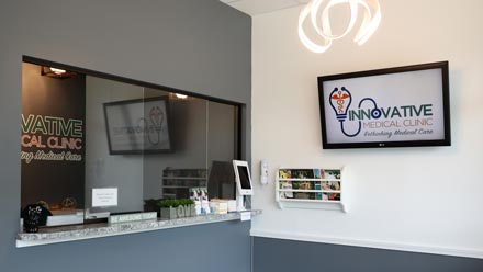 The clinic check-in window with the logo on the wall to the right.