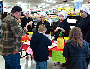 A family samples food at a grocery store.