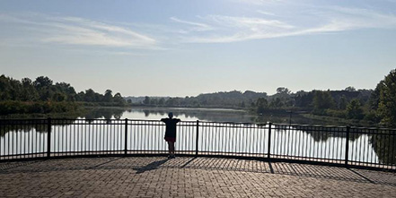 A person standing by a lake, BaratHaven Lake, Dardenne Prairie, St. Charles County Missouri.