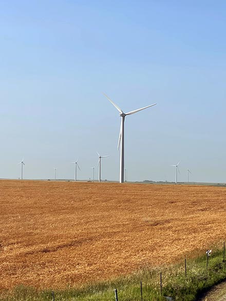 Four men at a wide turbine construction site.