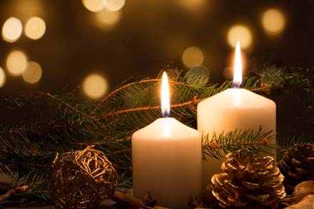 Candles lit around holiday decorations.