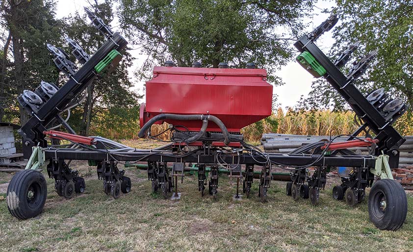 A row-unit based interseeder used to seed cover crops in a field of growing corn or soybeans.