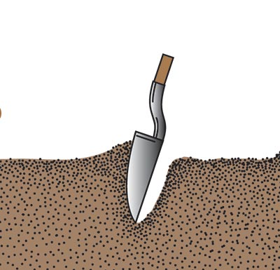 The handle of a shovel stuck straight down into the ground being pushed away and then the blade pulled up to remove soil