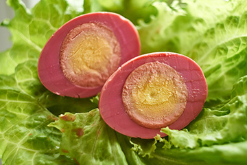 Sliced red beet egg on lettuce