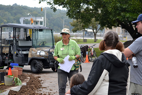 A Master Gardener teaching volunteers about pollinator gardening during an outdoor public event.