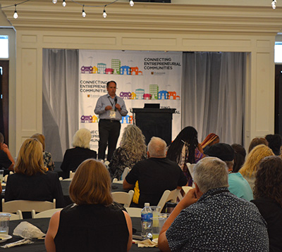 A man speaking to a room of people.