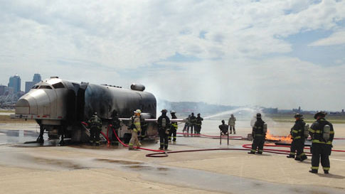 Firefighters extinguishing an aircraft fire on the tarmac.