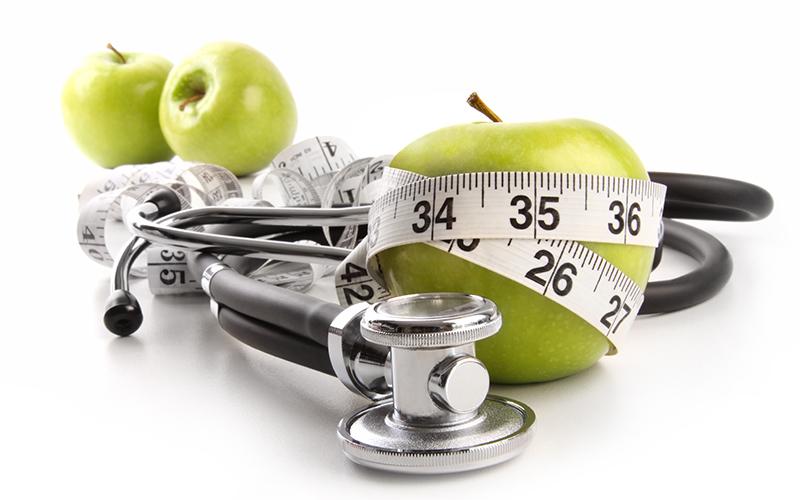 apple and stethoscope with measuring tape
