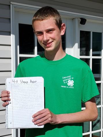 Luke Ketchum is pictured holding his journal documenting his 4-H project raising registered Dorpers.
