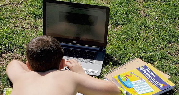 Kolton Kleeman does schoolwork on rented pasture so he can connect his laptop to the internet. 