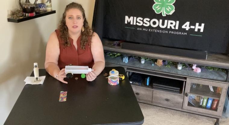 Chelsea Corkins, 4-H county engagement specialist covering Saline, Carroll and Chariton counties, discussing potential and kinetic energies as she demonstrates how to make a rubber band car.