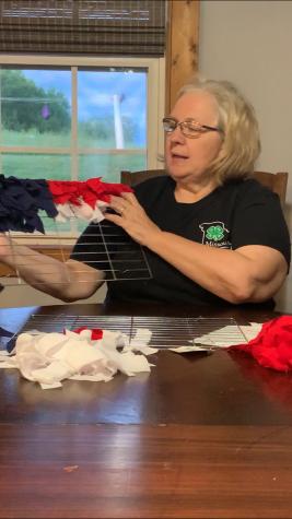 Becky Bentley, Chariton County youth program associate, demonstrates how to make an American flag using a cooling rack, fabric and stick-on stars.