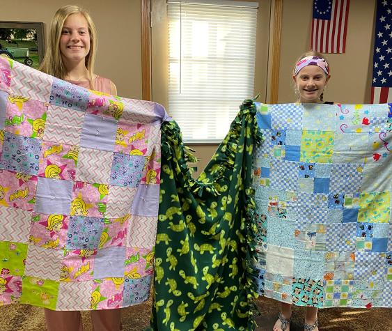 Kate Bello, left, and sister Libby, 4-H'ers in St. Charles County, show blankets they made for Project Linus, which organizes the donation and distribution of handmade blankets to ill or needy children.