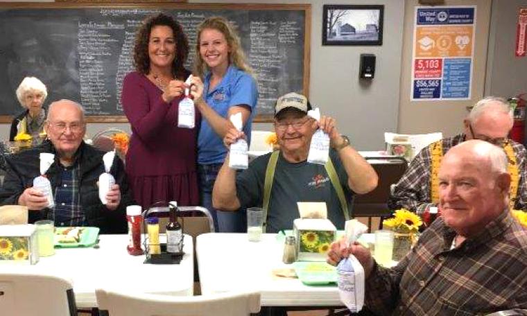 Aly Francis, standing at right, presents ground pork from her barrows to a senior center in Paris, Mo. Her efforts to curb food insecurity by donating pigs helped inspire Hogs for Hunger. Photo courtesy of Aly Francis.