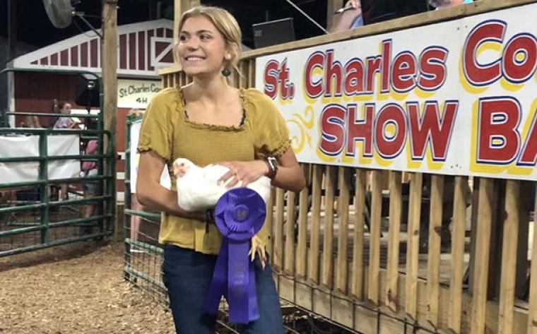 Girl holding a chicken at a fair
