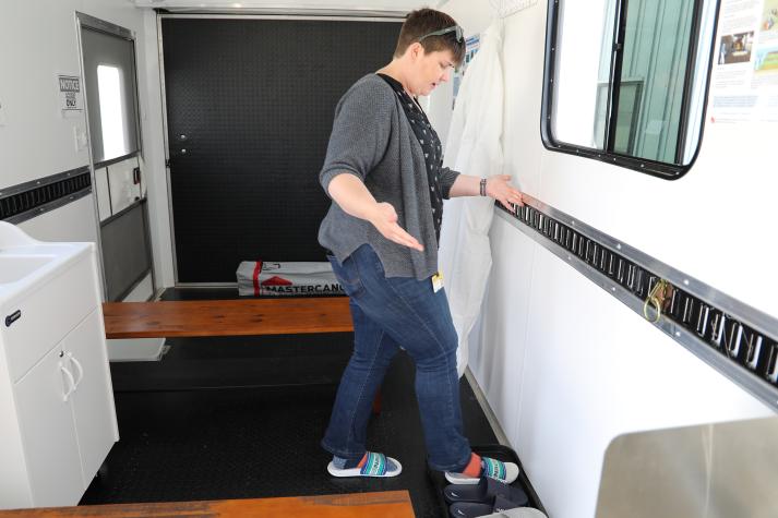 Cory Bromfield demonstrates the biosecurity trailer between the “dirty” and “clean” sides at the MU Beef Farm, Columbia, Mo. Photo by Julie Harker, University of Missouri.