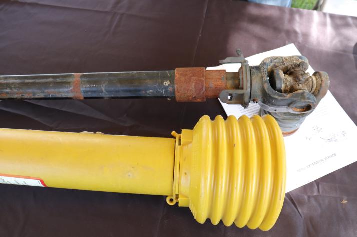 A PTO shaft beside one covered for protection.