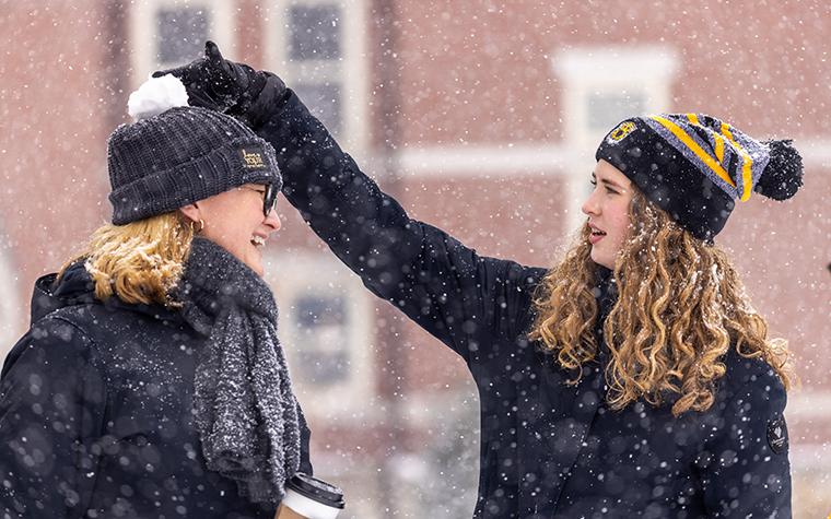 Two women on the Mizzou campus during the first snow of winter