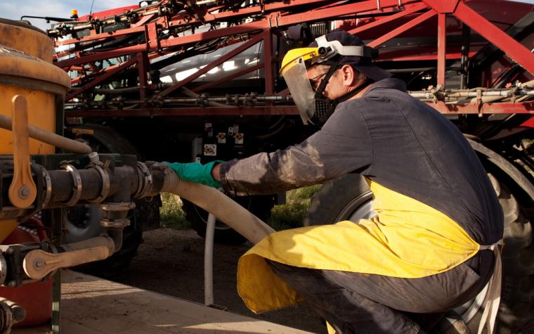 Pesticide applicator wearing personal protective equipment. Stock photo.