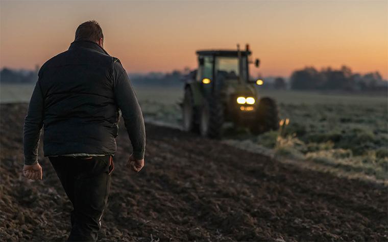 Man walking toward tractor in field