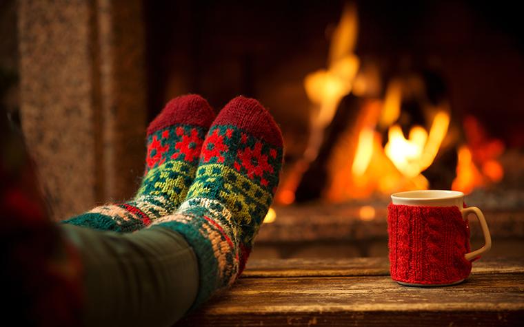 Fireplace, a mug and a pair of feet in festive socks