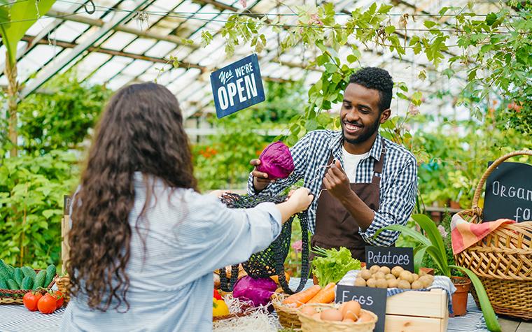 Man selling fresh produce to a woman