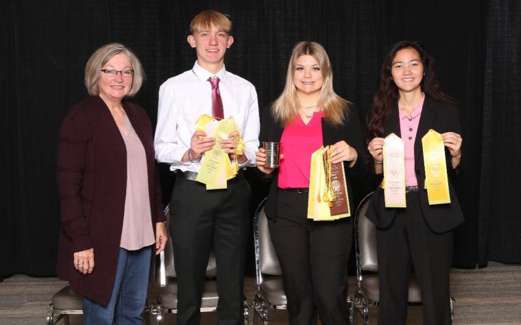 Dairy Judging Team coach with winning team members holding ribbons