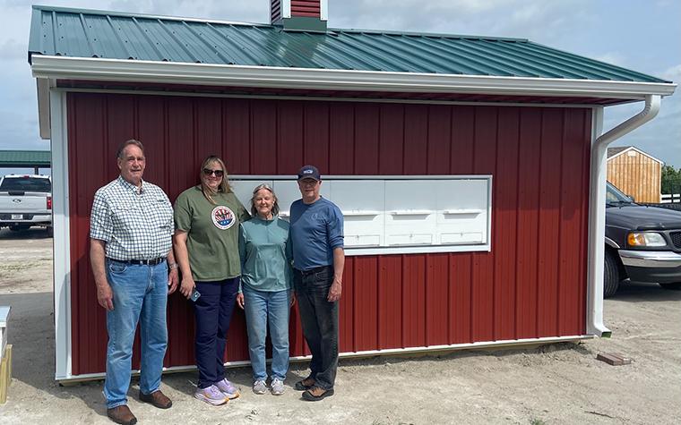 People standing in front of beehouse