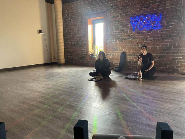 Moon Yoga instructors Allene and Alyson seated at front of class.