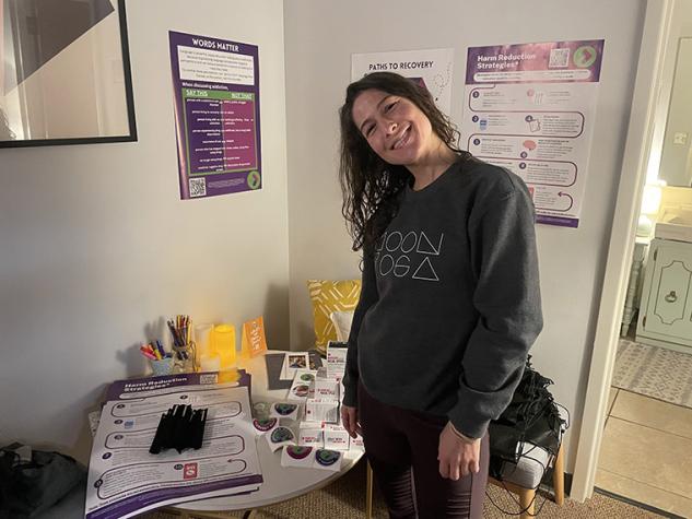 Moon Yoga instructor Allene standing next to a table with RFW information and give-away items.