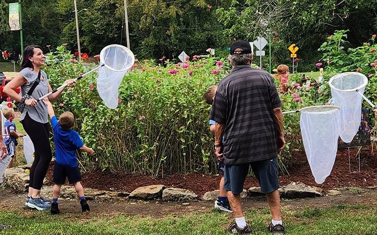 People in pollinator garden with butterfly nets