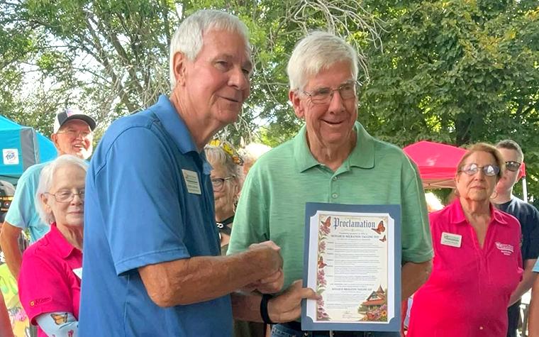 Two men, one holding a proclamation