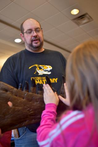 Casey Holliday, associate professor in the MU School of Medicine, displays a replica of part of the jawbone of a T. rex. The original skeleton, named Stan, is in South Dakota. Photo by Michael Hicks.