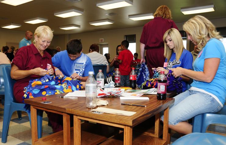 (Left to right) Inmate Judy Henderson makes blankets for the Puppies for Parole project with her grandson, Jarred, her granddaughter, Jordan, and her daughter, Angel, during a 4-H LIFE visit at the Chillicothe Correctional Center. Service projects like thRoger Meissen/MU Cooperative Media Group